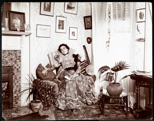 A woman lounging in a chair, reading a book